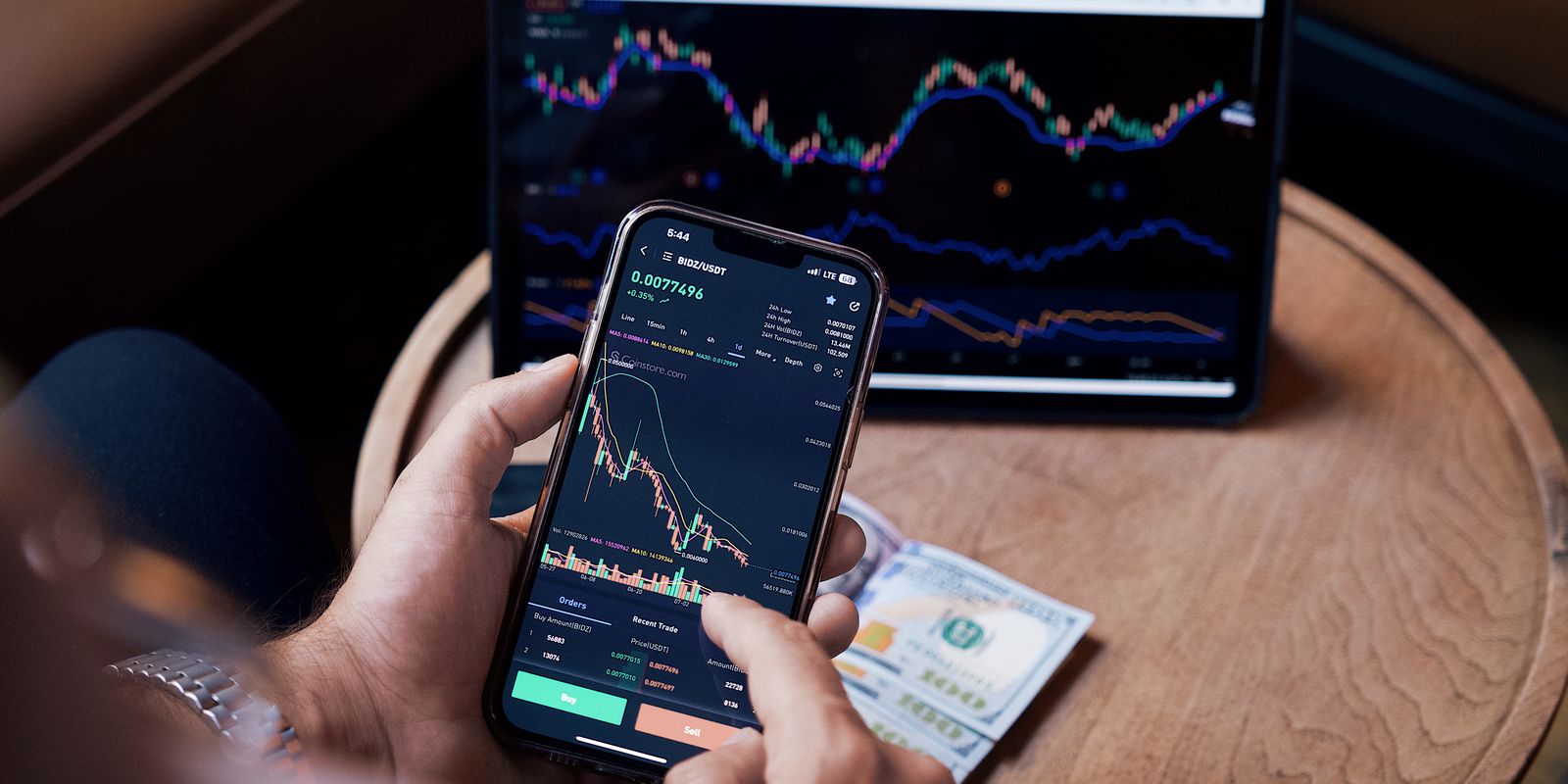 App di investimento crypto su schermo mobile tenuto in mano, interfaccia scura con accenti neon